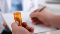 A doctor writes a prescription for a medication