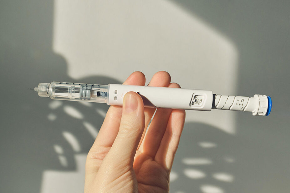 A person holds a GLP-1 weight-loss injection pen
