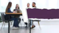 Team of businesspeople working together at table in office, blurred view. Image is torn from right showing a dark purple underneath