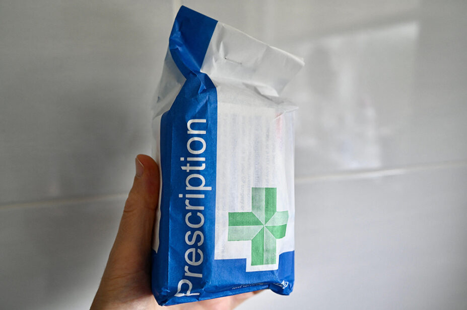 A person holds an NHS branded prescription bag
