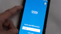 A person uses the NHS App on their smartphone