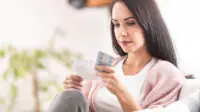 A woman reads a patient information leaflet before taking medication
