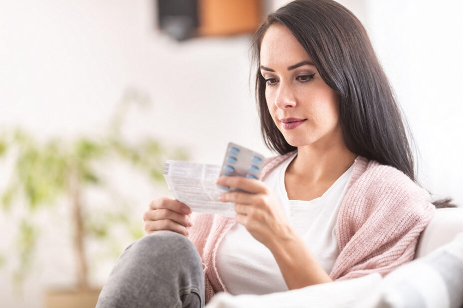 A woman reads a patient information leaflet before taking medication
