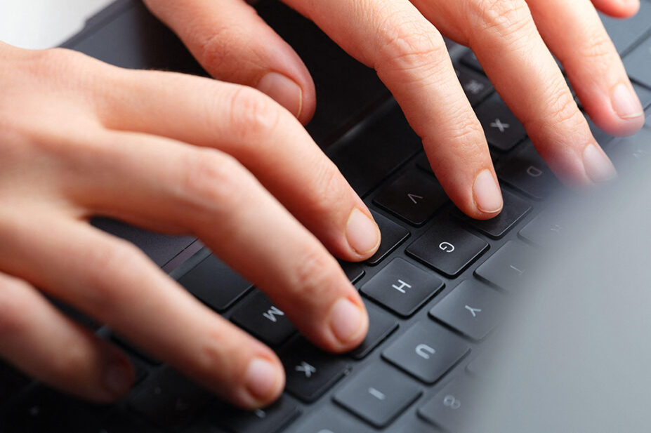 A close-up image of a person typing on a computer keyboard