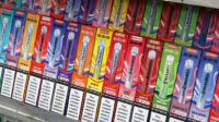 The shelves of a vape shop with an assortment of disposable vapes