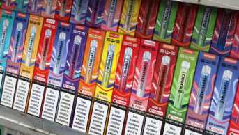 The shelves of a vape shop with an assortment of disposable vapes