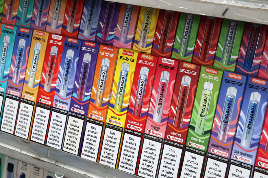 The shelves of a vape shop with an assortment of disposable vapes