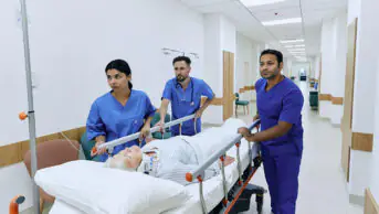Nurses wheel a patient through a hospital corridor