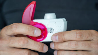 Close up view of man using medicine dry powder inhaler for treatment asthma or COPD diseases