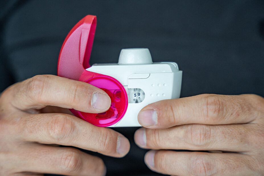Close up view of man using medicine dry powder inhaler for treatment asthma or COPD diseases