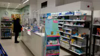 Customers at prescription counter in boots chemist