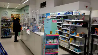 Customers at prescription counter in boots chemist