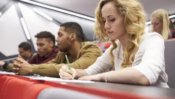 Female student taking notes in a university lecture theatre