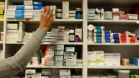 A pharmacist stocking shelves in a pharmacy
