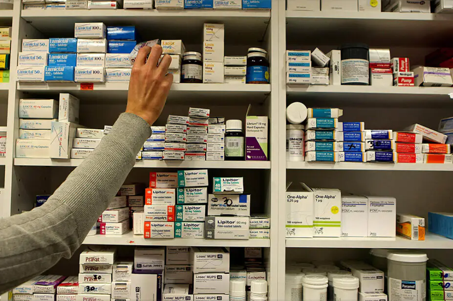 A pharmacist stocking shelves in a pharmacy